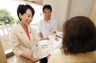 紙面を広げて「赤旗」購読を呼びかける畑野君枝衆院議員（左）＝８月２７日、川崎市川崎区